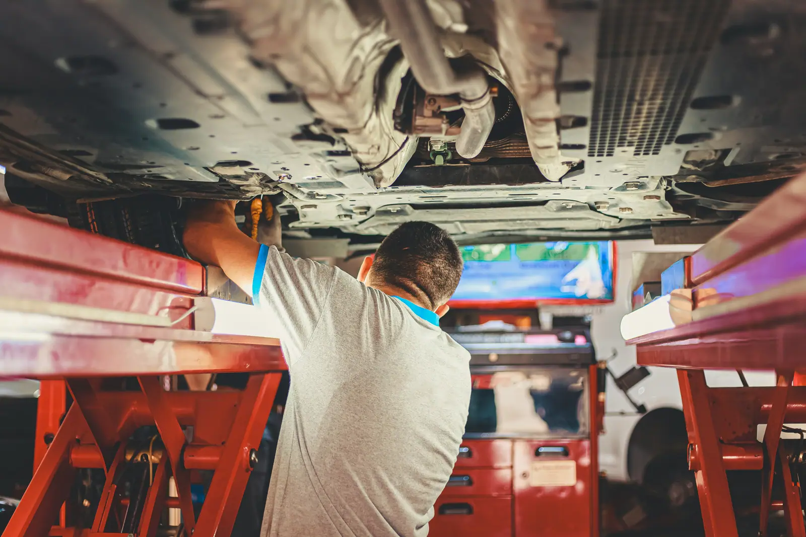 A mechanic checking a truck with a tablet in a service bay