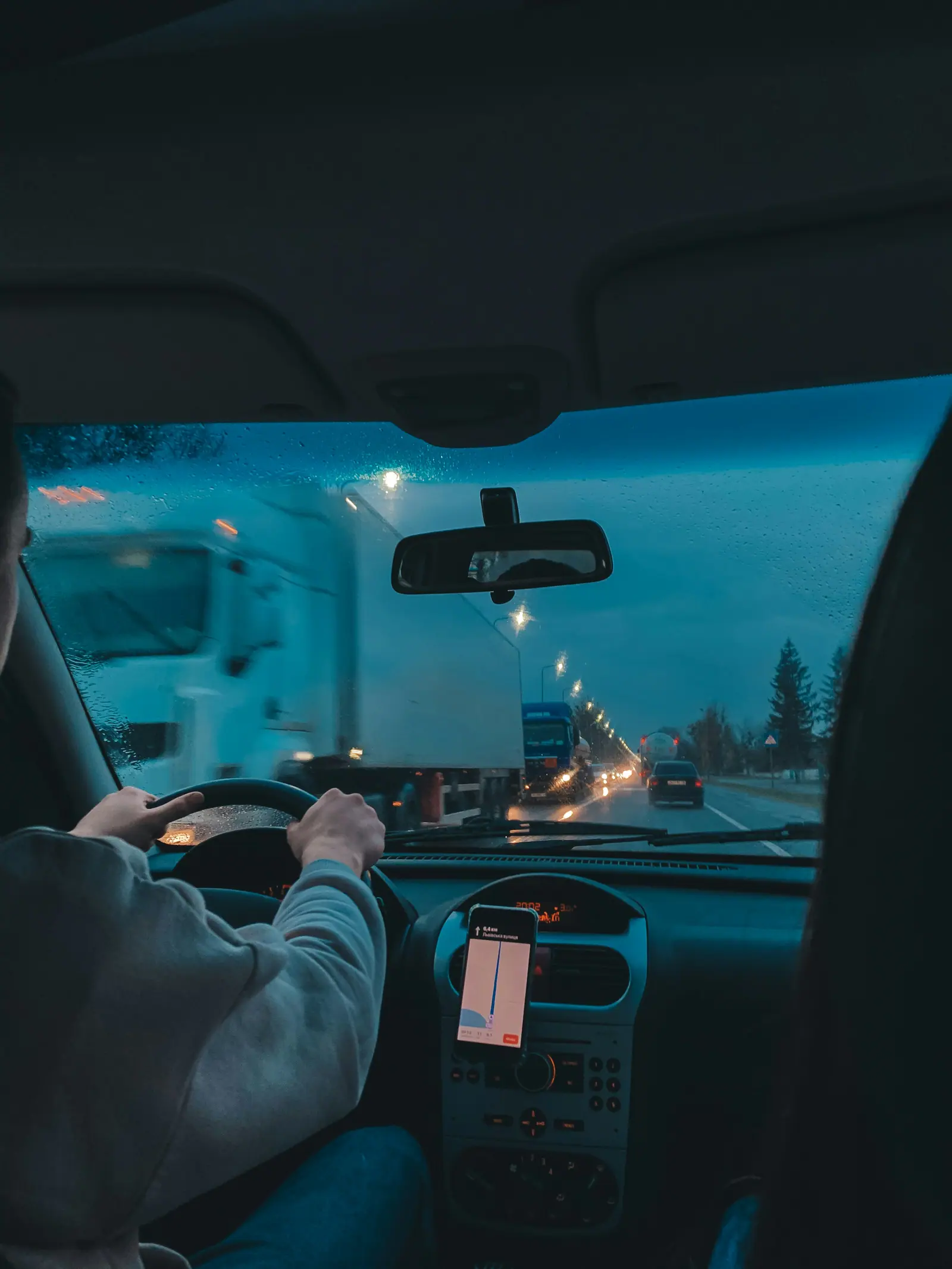 A truck driver at the wheel, seen from inside the cab